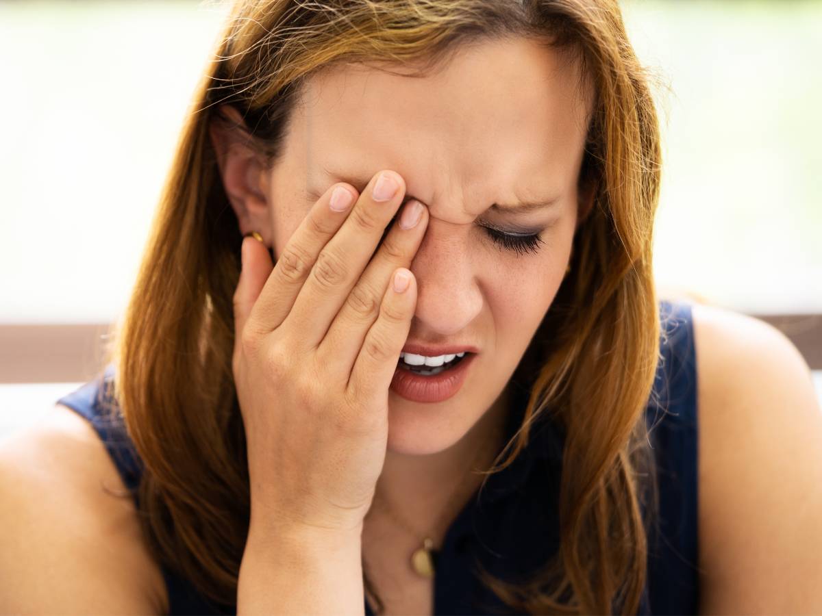 Kobieta trzyma się za oko. Obrazek w artykule Ból oka przy mruganiu i dotykaniu. Znajdź przyczyny i sposoby leczenia