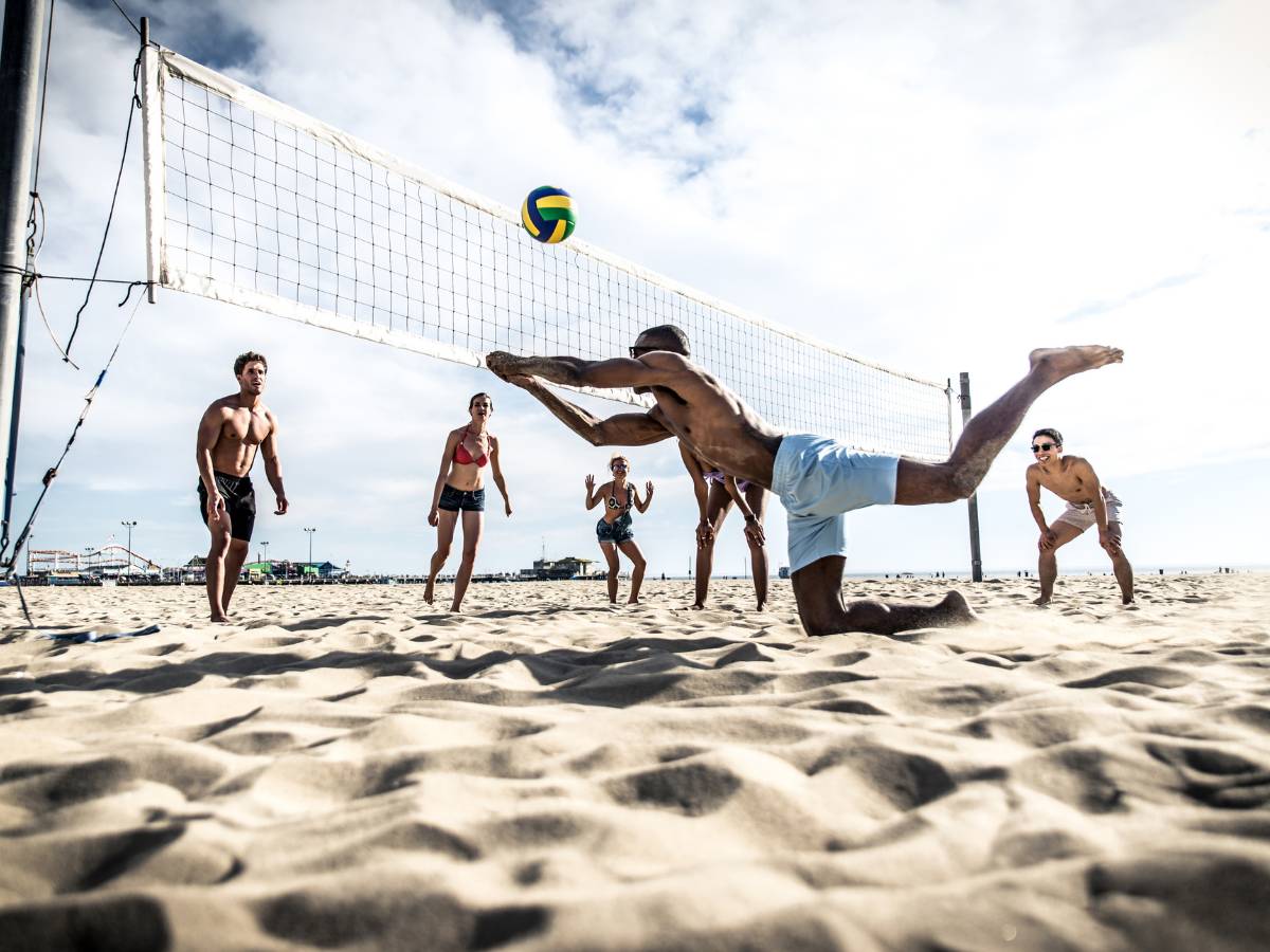 Grupa grająca na plaży. Obrazek w artykule Okulary do siatkówki plażowej. Odkrywamy, jakie okulary do grania na plaży są najlepsze