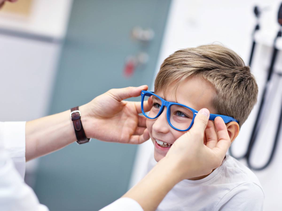 Młody chłopak mierzy okulary. Obrazek w artykule Okulary progresywne co to? Przewodnik po wielozakresowych szkłach