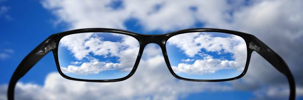 Okulary na tle nieba. Obrazek w artykule Rodzaje szkieł do okularów. Wyjaśniamy jakie są  szkła korekcyjne i jakie mają właściwości